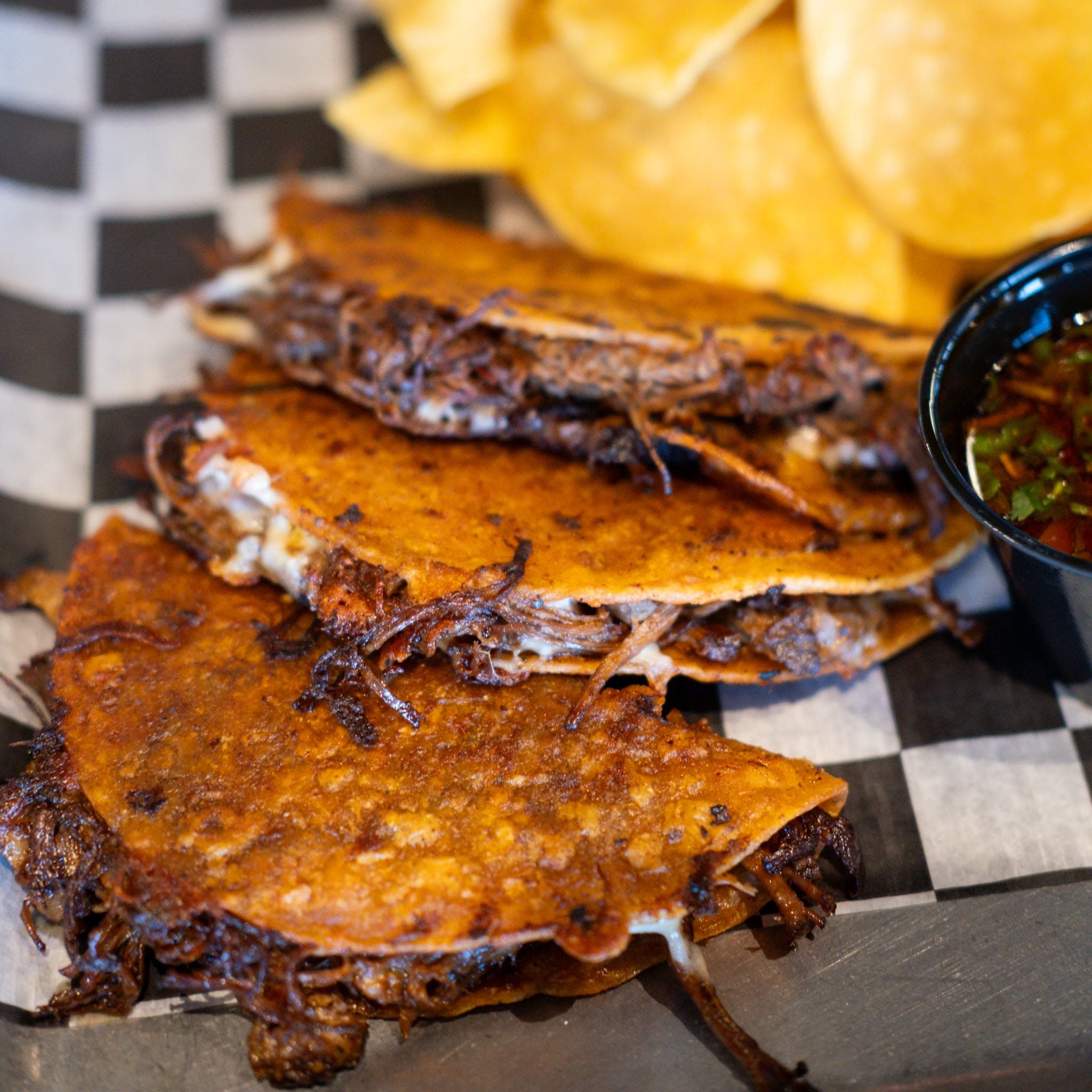 Crispy birria quesadilla with chips and consommé